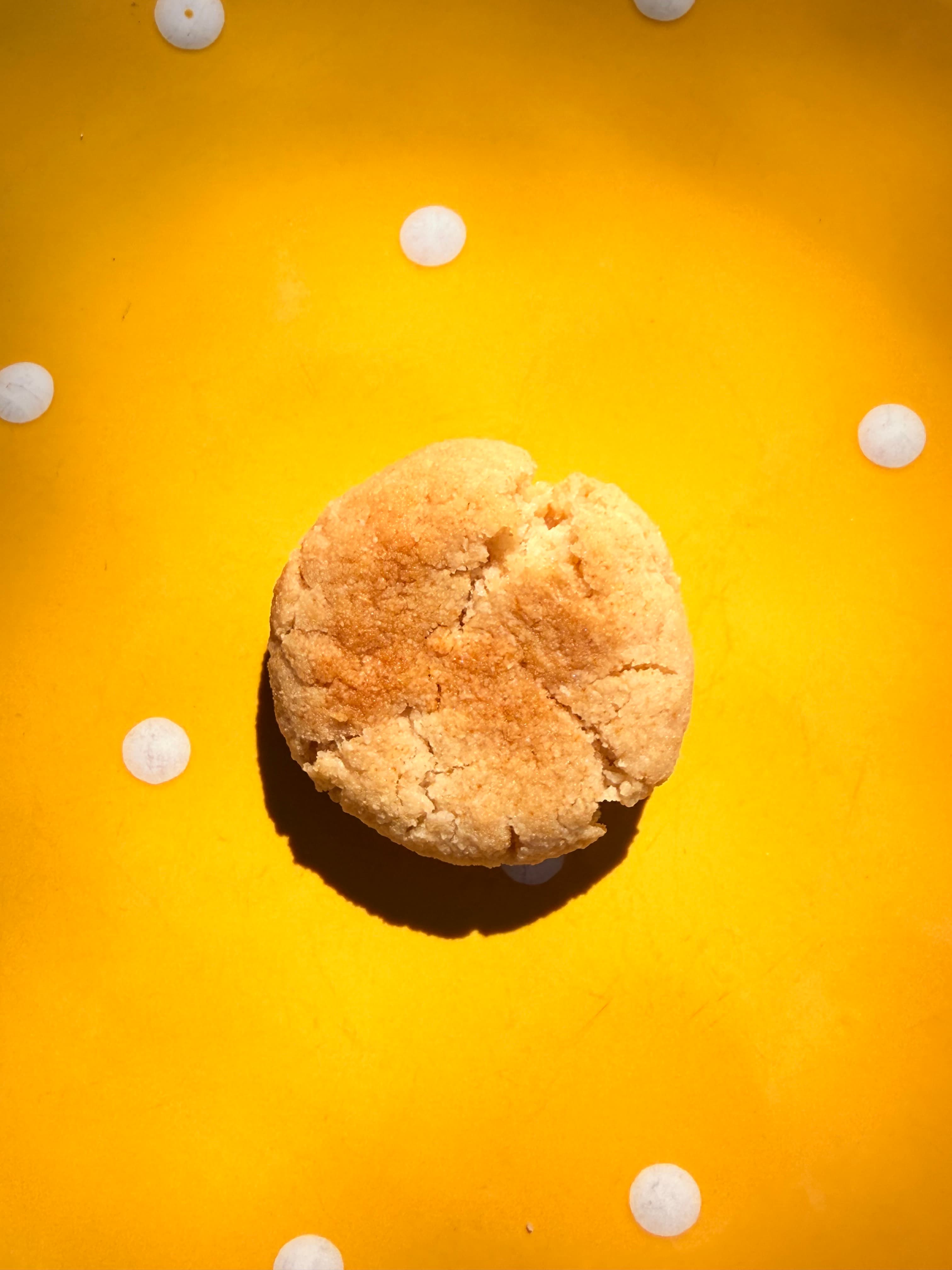 Golden Crumble cookie on a sunny yellow background with dotted accents